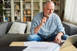 Foto: Älterer Mann füllt Unterlagen aus